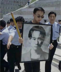 ​1993年，黄家驹的葬礼，弟弟捧着遗照，有人跪在地上哭，哀荣备至